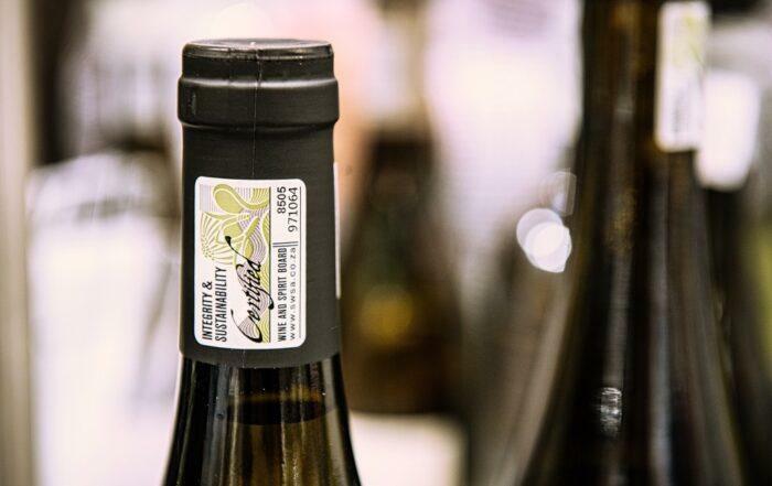 Südafrikanische Weinflasche am Flaschenhals mit dem offiziellen Wine of Origin Siegel und IPW-Zertifizierung
