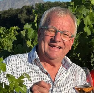 Pieter Ferreira mit einem Glas Cap Classique im Weinberg